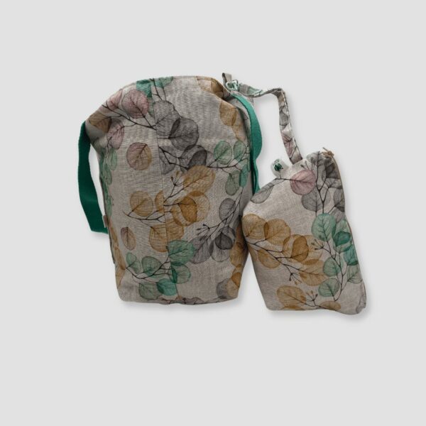 Cara lateral de bolso estampado floral y colores tenues en amarillo, lila y verde con fondo blanco.