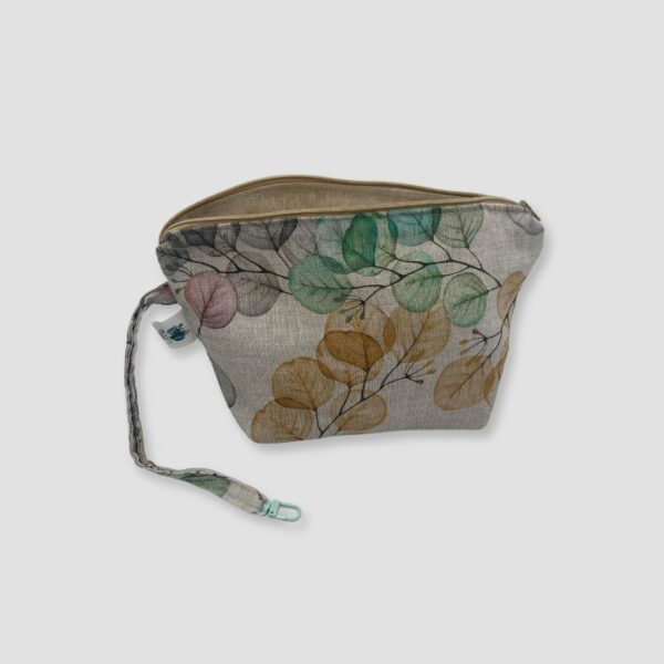 Neceser floral con cremallera abierta en colores tenues, amarillo, verdes y lila con fondo blanco